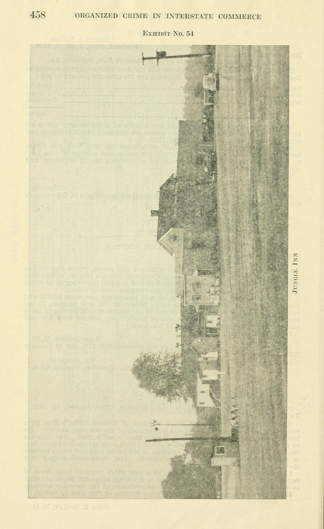 Exhibit No. 54, a photograph printed sideways of a road with low buildings beside it and the caption "Jungle Inn".