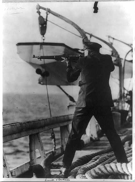 An officer aboard the Coast Guard cutter Seneca firing at a fleeing boat.