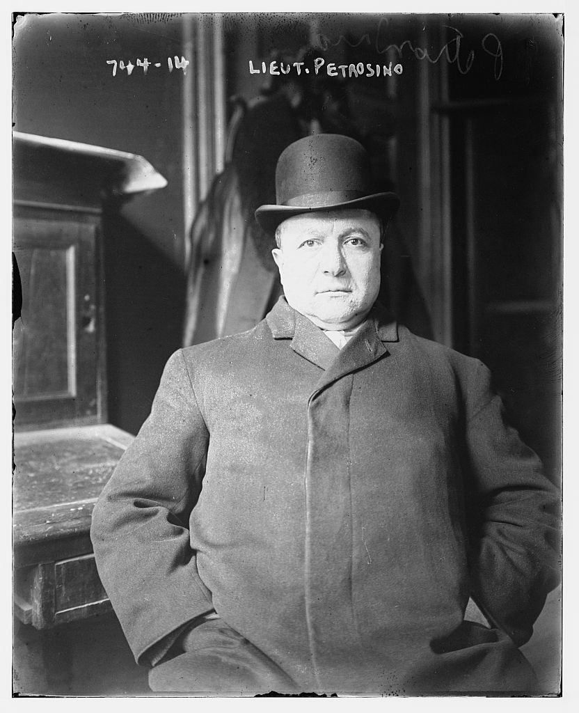 Joseph Petrosino seated indoors in a bowler hat and heavy overcoat, hands in his pockets; the negative is captioned 'Lieut. Petrosino' and numbered 744-14.