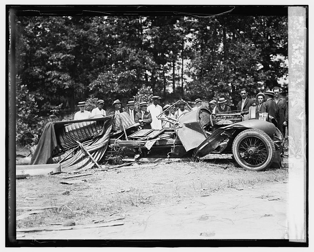 A wrecked Stutz automobile with several people standing around it.