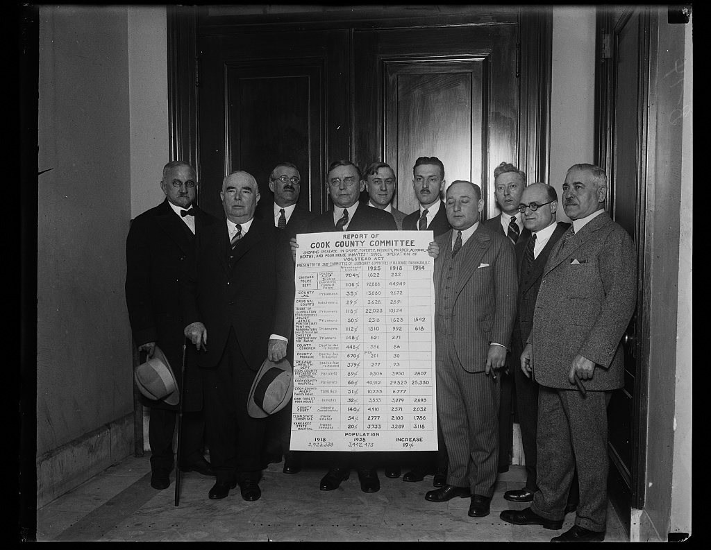 Ten men in a corridor holding a placard headed Cook County Committee.