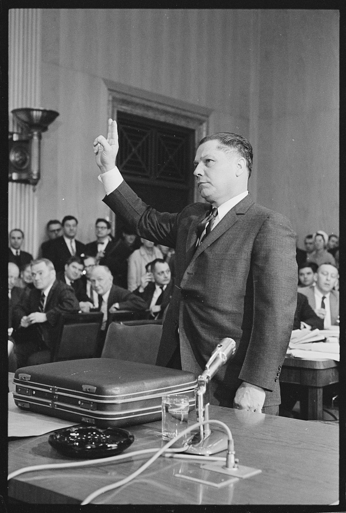 Jimmy Hoffa standing with his right hand raised before a Senate committee, 24 January 1961.