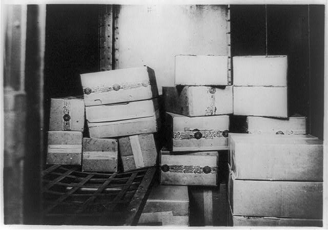 Rows of wooden cases of whiskey stacked in a storage room.