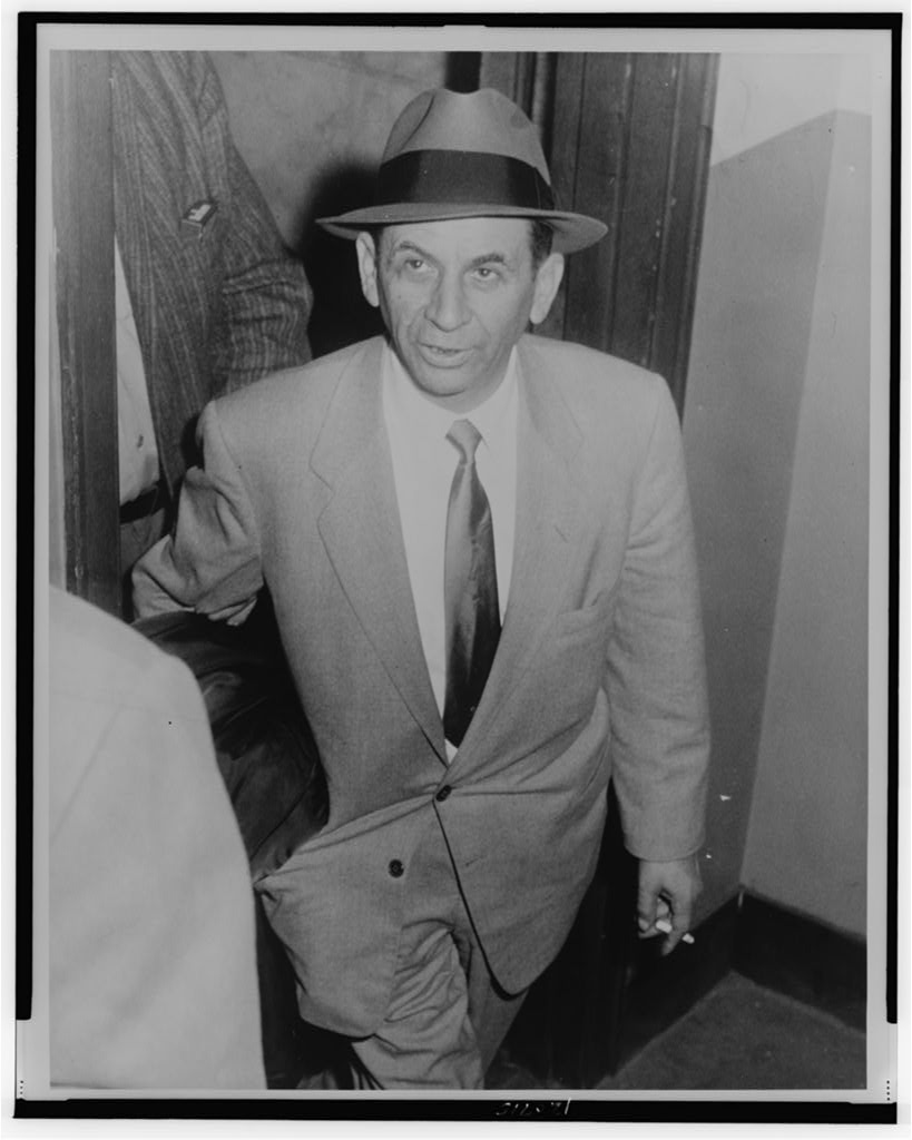Three-quarter-length photograph of Meyer Lansky at a New York City police station.