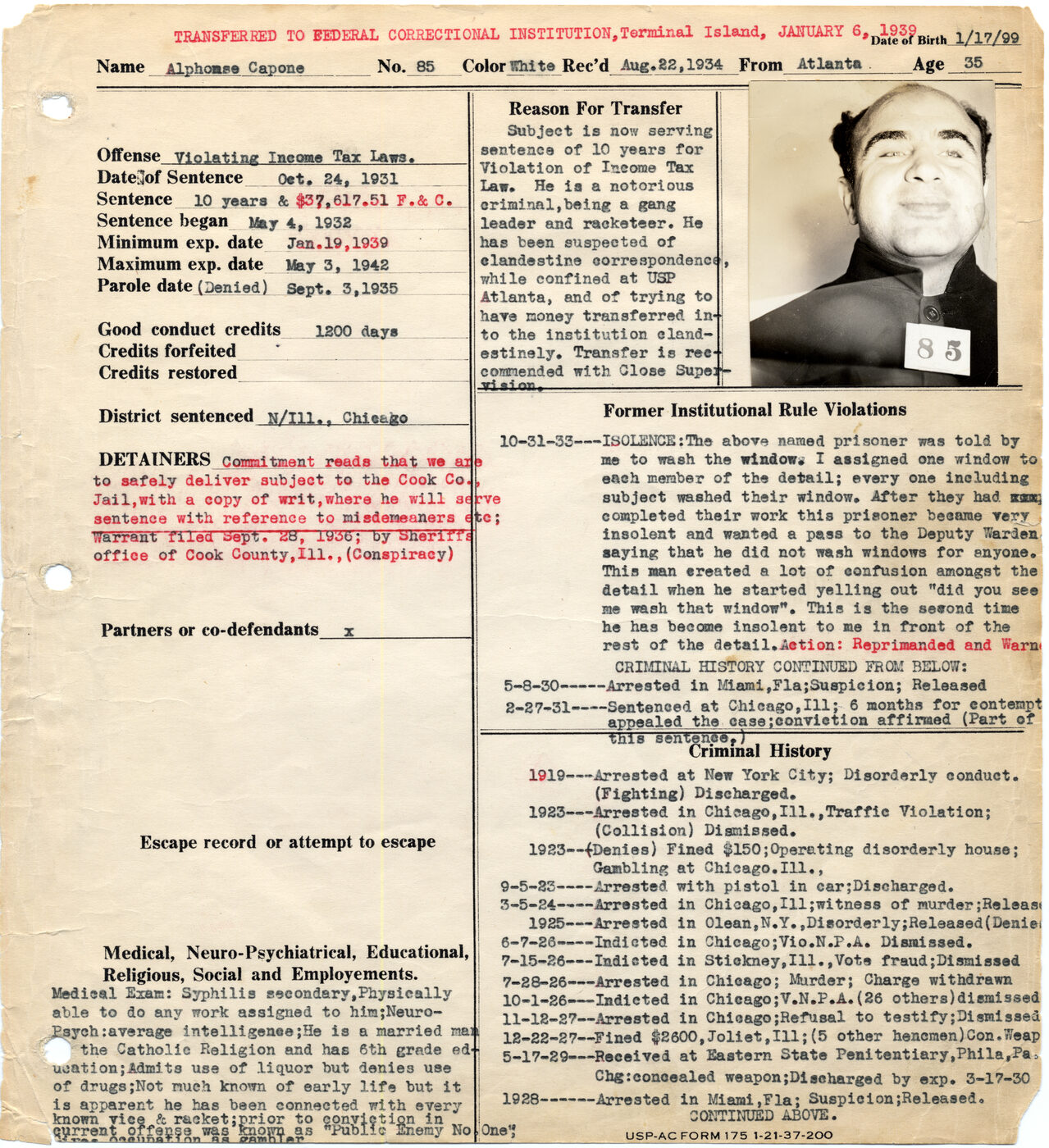 Typed Alcatraz warden's notebook form for Alphonse Capone, No. 85, with a red header noting transfer to Terminal Island and a pasted photograph of Capone in prison clothing holding a card numbered 85.